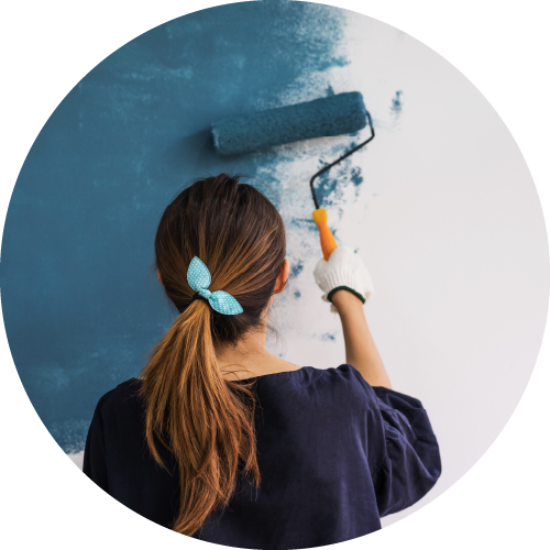 Photo of a woman painting a wall with a roller from behind to show a VOC event